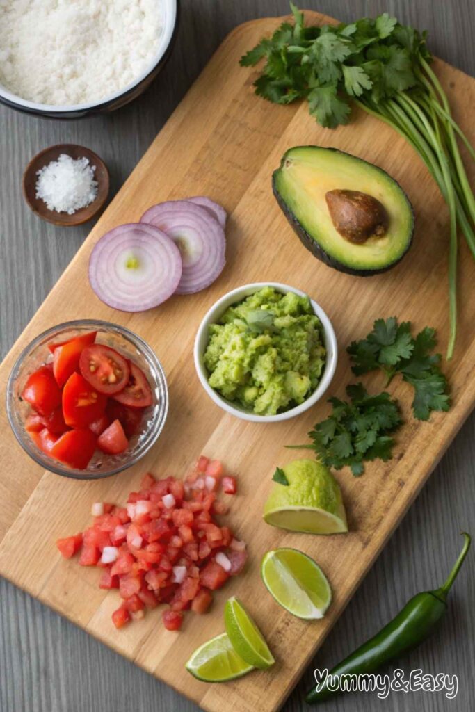 Fresh ingredients for homemade guacamole on a wooden board.